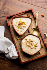 Sweet Rabdi or Lachha Rabri or basundi, made with pure milk garnished with dry fruits. Served in a bowl over moody background. Selective focus