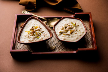 Sweet Rabdi or Lachha Rabri or basundi, made with pure milk garnished with dry fruits. Served in a bowl over moody background. Selective focus