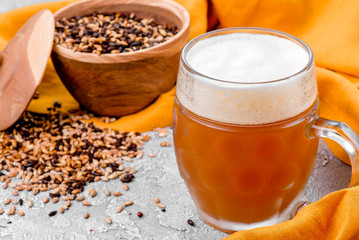 Malt grain and a glass of beer. Mixed varieties of malted grain on a gray background. close-up