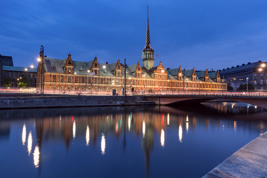 The Old Stock Exchange Boersen wirh its mirror reflection in canal at night, Copenhagen, capital of Denmark