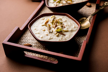 Sweet Rabdi or Lachha Rabri or basundi, made with pure milk garnished with dry fruits. Served in a bowl over moody background. Selective focus