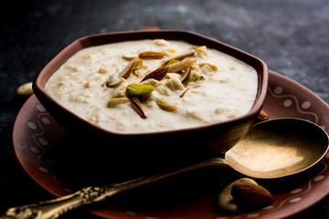 Sweet Rabdi or Lachha Rabri or basundi, made with pure milk garnished with dry fruits. Served in a bowl over moody background. Selective focus