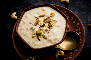 Sweet Rabdi or Lachha Rabri or basundi, made with pure milk garnished with dry fruits. Served in a bowl over moody background. Selective focus