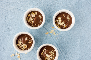 Ramekins filled with Chocolate Pudding on Blue Background