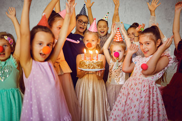 Children with a birthday cake have fun.