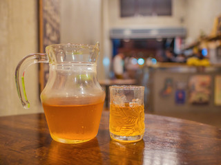 Harbal Tea in the Water pitcher and the Glass on the Wooden table in the cafe