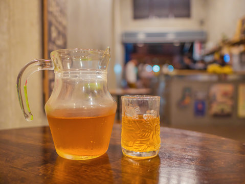 Harbal Tea in the Water pitcher and the Glass on the Wooden table in the cafe