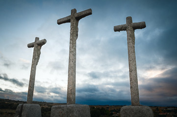 cruz religiosa de piedra de granito en primer plano con cielo azul