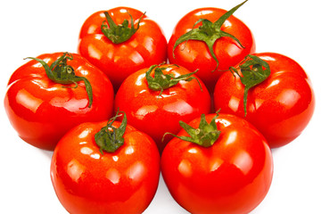 a pile of fresh red tomatoes on a white background