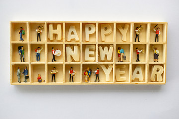 box with word "happy new year" and miniature people
