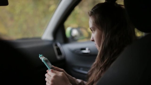 Mom Picks Up Daughter From School By Car. The Daughter Is Sitting In The Front Seat Is Mobile And Talking To My Mother.