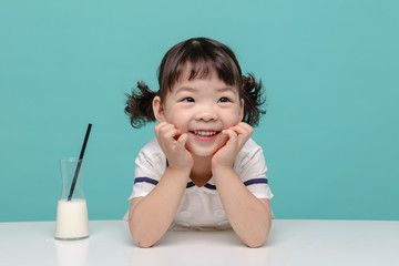 Little pretty Asian girl laughing portrait with milk and bread, healthy and happy lifestyle.