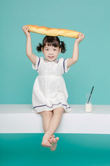 Little pretty Asian girl laughing portrait with milk and bread, healthy and happy lifestyle.