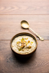 Sweet Rabdi or Lachha Rabri or basundi, made with pure milk garnished with dry fruits. Served in a bowl over moody background. Selective focus