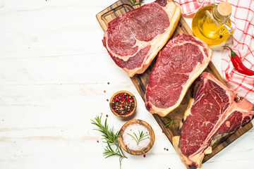 Raw meat beef steak on white top view.