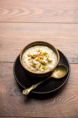 Sweet Rabdi or Lachha Rabri or basundi, made with pure milk garnished with dry fruits. Served in a bowl over moody background. Selective focus