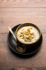 Sweet Rabdi or Lachha Rabri or basundi, made with pure milk garnished with dry fruits. Served in a bowl over moody background. Selective focus