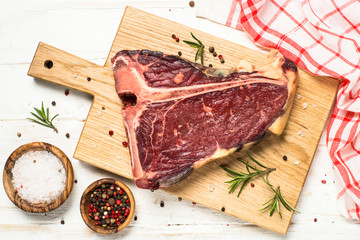 T-bone beef steak on white with spices.