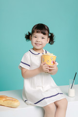 Little pretty Asian girl laughing portrait with milk and bread, healthy and happy lifestyle.