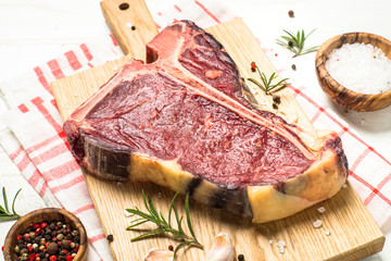 T-bone beef steak on white with spices.