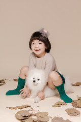 Little pretty Asian girl sitting in an autumn background.