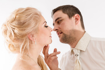 Beautiful newlywed couple in wedding attire are kissing, close-up