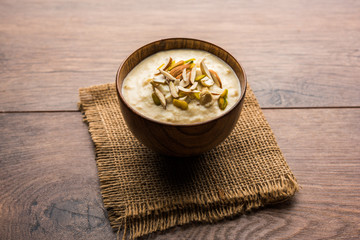 Sweet Rabdi or Lachha Rabri or basundi, made with pure milk garnished with dry fruits. Served in a bowl over moody background. Selective focus