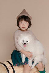 Little pretty Asian girl sitting in an autumn background.
