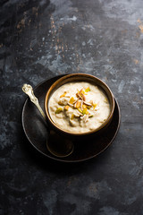 Sweet Rabdi or Lachha Rabri or basundi, made with pure milk garnished with dry fruits. Served in a bowl over moody background. Selective focus
