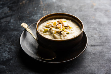 Sweet Rabdi or Lachha Rabri or basundi, made with pure milk garnished with dry fruits. Served in a bowl over moody background. Selective focus