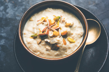 Sweet Rabdi or Lachha Rabri or basundi, made with pure milk garnished with dry fruits. Served in a bowl over moody background. Selective focus