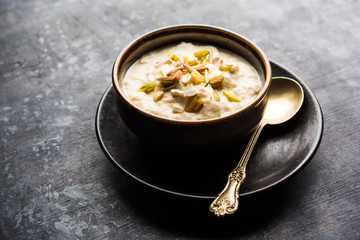 Sweet Rabdi or Lachha Rabri or basundi, made with pure milk garnished with dry fruits. Served in a bowl over moody background. Selective focus
