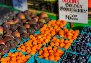 Fresh fruits like gooseberry, figs and blueberries for sale at a stall at Pike Place Market in Seattle, Washington