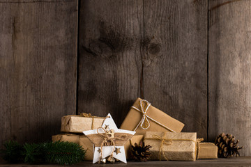 Kraft paper gifts and a Christmas star decoration on an old wooden bookshelf.