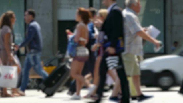 Side view blurry pedestrians walking.
People crossing a street in the city of Barcelona.