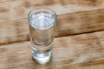 A glass of water on a wooden background.
