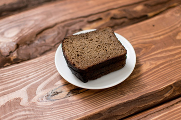Slices of black bread on a wooden background.