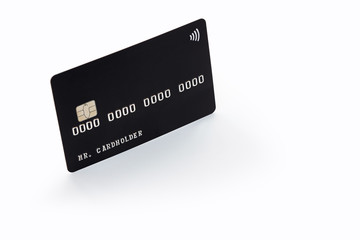 Black credit card on white background with natural shadow