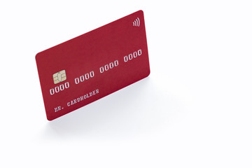 Red credit card on white background with natural shadow