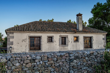 Vieja casa rural/ vieja casa rural con muro de piedra delante.