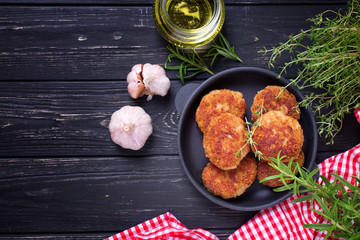Homemade cutlets with herb and spices  on  black wooden background.