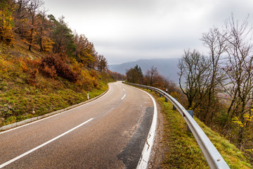 Fototapeta premium Autumn forest road landscape. Mountain forest road in autumn.
