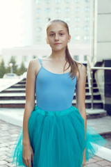 Portrait of ballet dancer dancing outdoor. Young ballerina in blue sportwear. Portrait of young lovely pretty beautiful girl in the park.