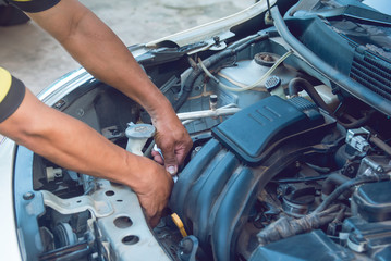 Car mechanic working with wrench in garage. Repair service.