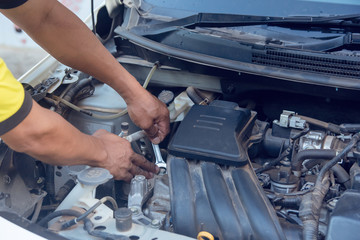 Car mechanic working with wrench in garage. Repair service. © Achira22