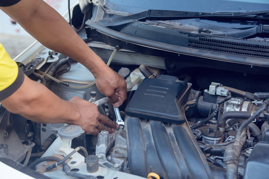 Car mechanic working with wrench in garage. Repair service.
