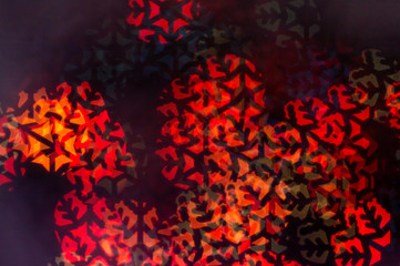  Beautiful curly bokeh of a cold light garland in the form of a snowflake on a dark background....