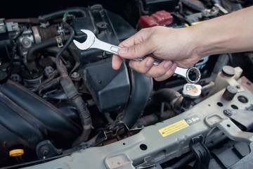 Fototapeta na wymiar Car mechanic working with wrench in garage. Repair service.