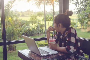 Young asia woman sitting relax alone at coffee shop after working on a laptop