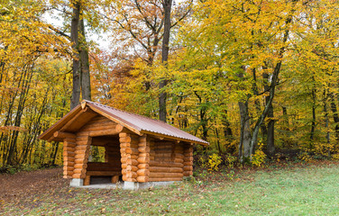 Wooden hut made of tree trunks at the edge of the forest.